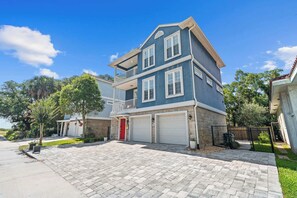 Ein zweistöckiges Haus mit Garage, rotem Eingangstür und Balkon.