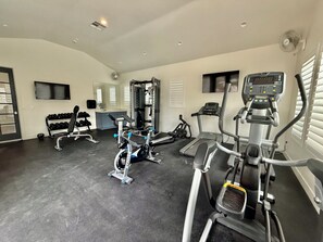 A gym with various exercise equipment, including treadmills, an elliptical, and free weights. - Athlete's Retreat | Pool, Hot Tub, Pet Friendly (Washington)