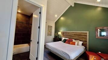 A bedroom with a wooden bed, a nightstand, a bedside table, and a green wall.