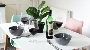 A dining table with wine glasses, a bottle, and a potted plant. - Room-double Room in Wolverhampton City c (Wolverhampton)