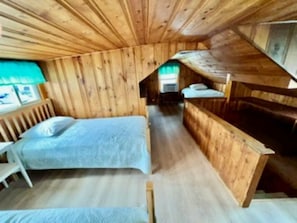 A wooden cabin with a loft-style bedroom, a single bed, and a small desk area. - Wells Beach Cozy 2-bedroom condo in charming Wells across street from beach (Wells)