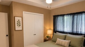 A bedroom with a bed, a ceiling fan, a window with curtains, a door, and a framed picture on the wall. - Perfect 3-bedroom house with AC in welcoming Harlingen (Harlingen)