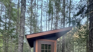 A small wooden cabin with a brown door and a welcome mat.