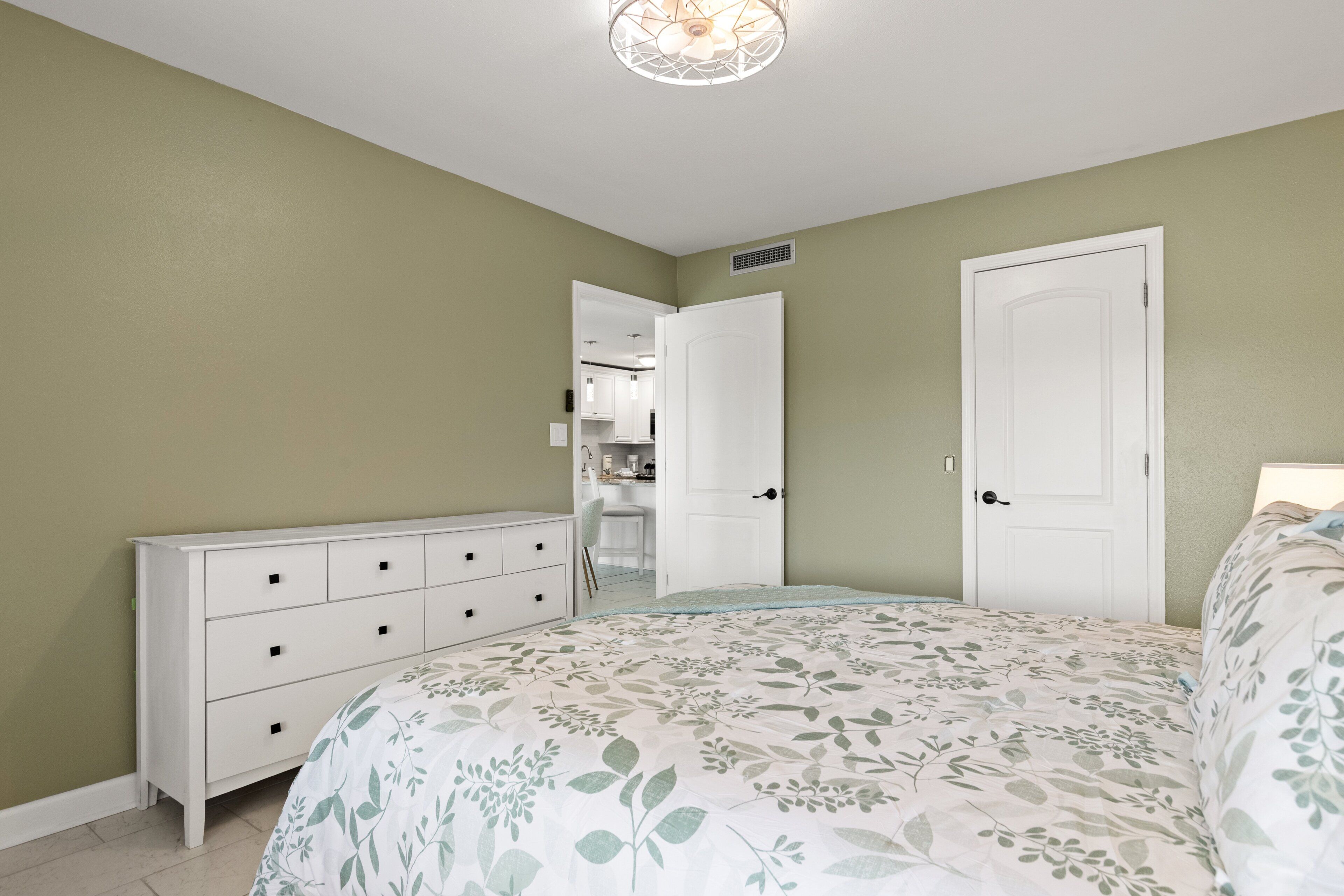 Ein Schlafzimmer mit Bett, Kommode und Kleiderschrank.
