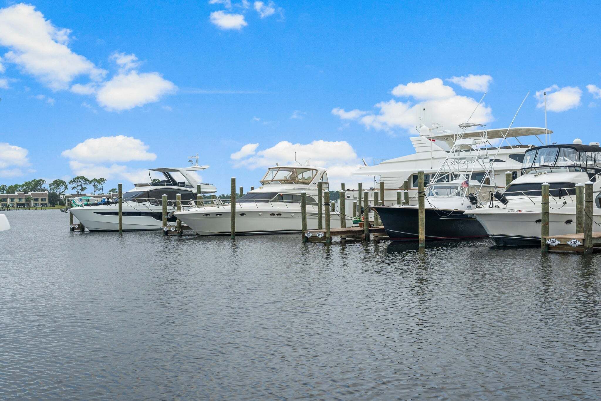A marina with several yachts docked at wooden piers.