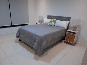 Ein modernes Schlafzimmer mit einem großen Bett, Nachttischen und einem Kleiderschrank.
