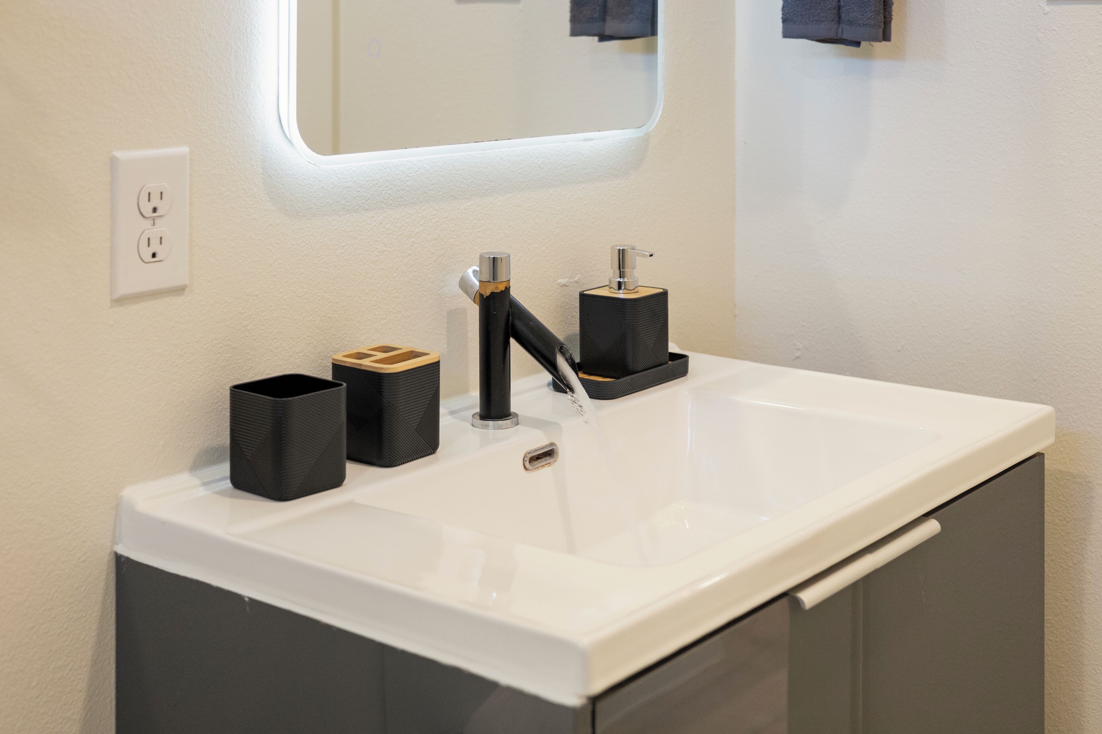 A bathroom with a white sink, black faucet, and a mirror above it.