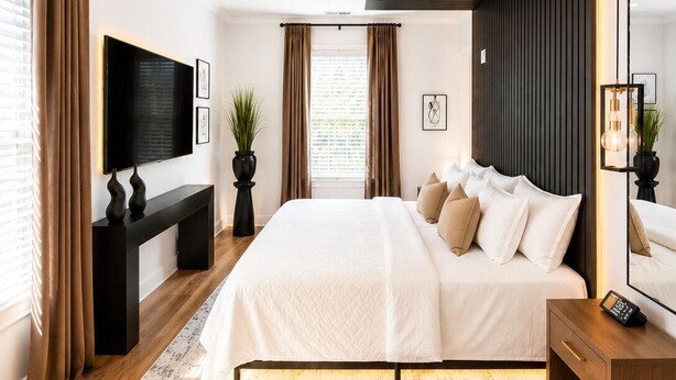 A modern bedroom with a large bed, a TV, a desk, and a mirror. - Midnight Luxe Suite with Walkable Areas, Keyless Check-in and Free Parking (Atlanta)