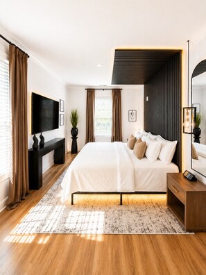 A modern bedroom with a large bed, a TV, a desk, and a mirror. - Midnight Luxe Suite with Walkable Areas and Free Parking (Atlanta)