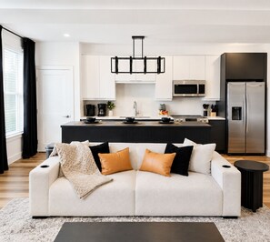 A modern kitchen with white cabinets, a stainless steel refrigerator, and a black countertop. - Midnight Luxe Suite with Walkable Areas, Keyless Check-in and Free Parking (Atlanta)
