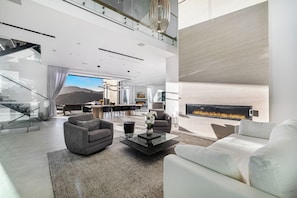 A spacious living area with a fireplace, modern furniture, and a view of the outdoors.