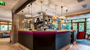 A modern bar area with a counter, pendant lighting, and a view of the outdoors.