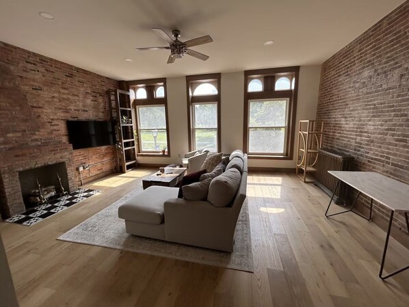 Ein Wohnzimmer mit Kamin, einer Couch, einem Couchtisch und einem Fernseher.