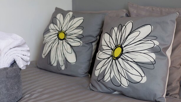 Two pillows with daisy designs on a bed. - Room-double Room Perfect for Contractors (Wolverhampton)
