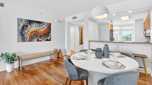 Un comedor moderno con una mesa redonda, sillas tapizadas en gris y un cuadro abstracto grande en la pared.