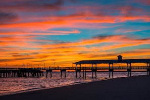 A pier extending into the water with a covered structure at the end. - 2 Bedroom Oceanfront Condo with Pool! (St. Simons Island)