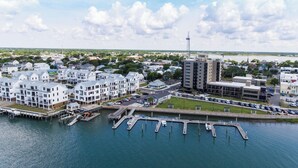 A marina with docked boats, a parking area, and residential buildings with balconies.