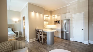 A modern kitchen with white cabinets, stainless steel appliances, and a central island with seating.