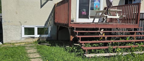 A house with a deck, a window, and a door.
