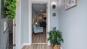 Un pasillo con una planta, un cartel de bienvenida y un mapa enmarcado en la pared.