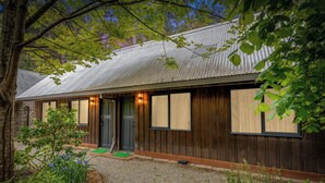 Un bâtiment de style rustique, doté d’un toit en métal, d’un revêtement en bois et d’une allée en gravier.