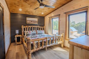 Ein Bett mit Holzrahmen, einer Steigedecke und einem Fenster mit Blick auf ein Gebäude.