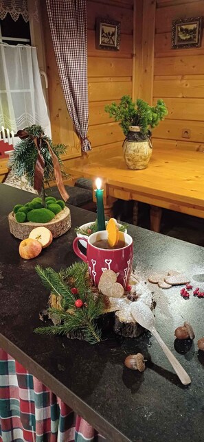 Ein Holzeinrichtung mit gedecktem Tisch, der eine Tasse, eine Kerze und verschiedene Speisen zeigt.