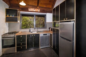 Una cocina moderna con estufa, lavamanos y refrigerador.