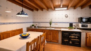 A kitchen with wooden cabinets, a sink, a microwave, and a stove. - Asturian House in Llanes - El Mayon del Cuetu Meré (Mere)