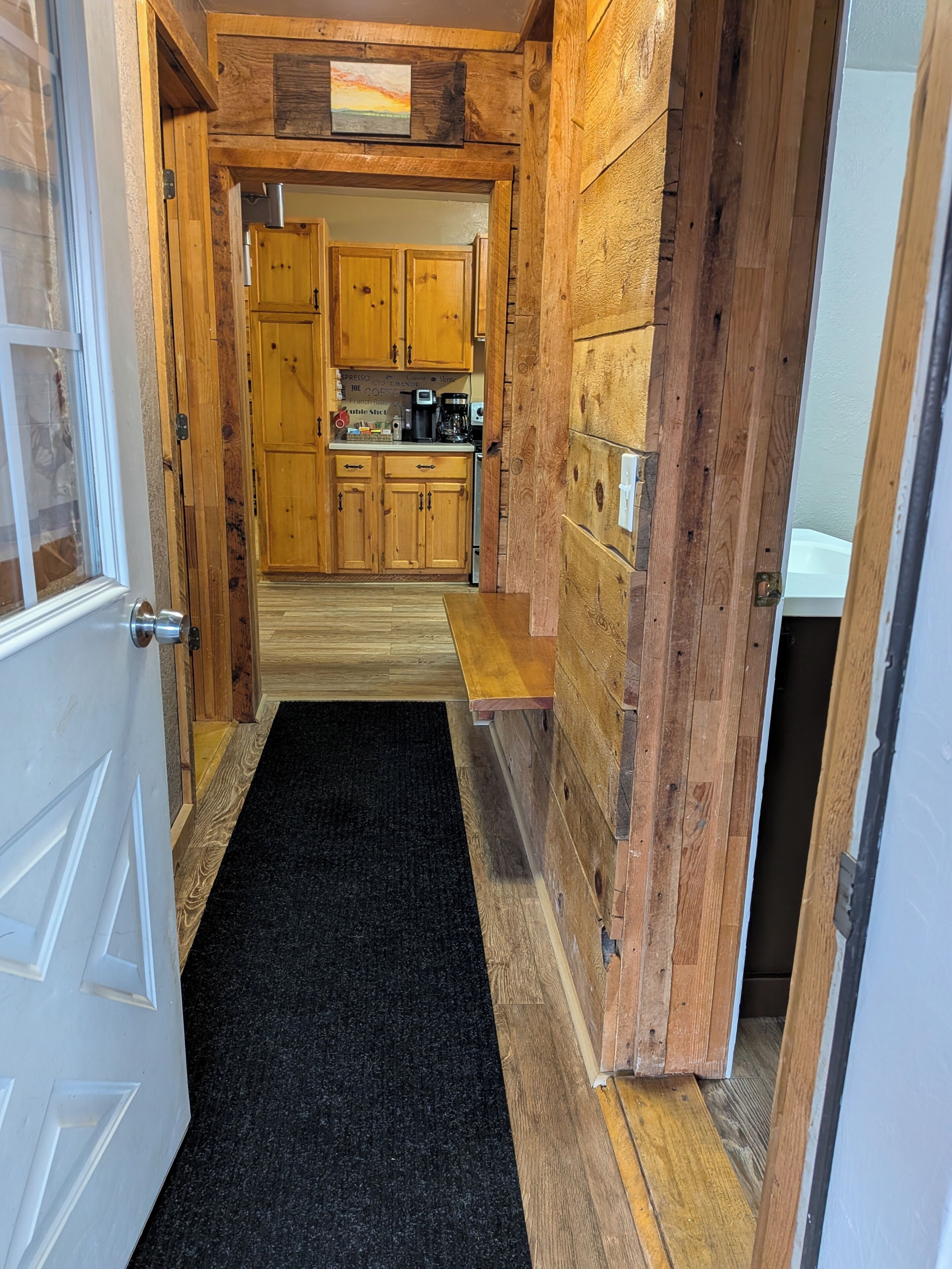 A wooden interior with a kitchen area, including cabinets and appliances.