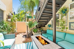 An outdoor patio with a fire pit, seating, and potted plants. - Luxury Hyde Park Retreat Sauna & Gym Group of 12 (Tampa)