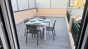 Ein Balkon mit Tisch für zwei Personen, Stühlen und Blick auf die Außenansicht des Gebäudes.