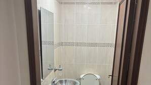 Une salle de bain avec un lavabo en verre, des toilettes et un espace douche.