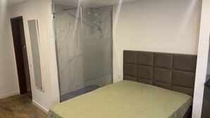 Une chambre à coucher avec un lit, une douche et une porte.