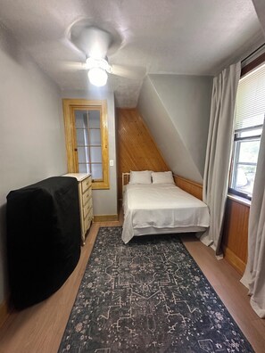 A bedroom with a bed, a dresser, a ceiling fan, a window with curtains, and a patterned rug. - 8 Acres of Privacy  Your Group Escape (Rockford)