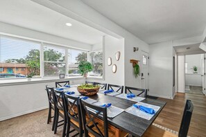 A dining area with a long table, chairs, and a plant centerpiece. - Seminole 4BR/2BA Pool, Game Room & Fenced Yard (Seminole)