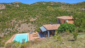A hillside villa with a swimming pool, outdoor seating, and a view of the surrounding hills. - Lovely home in Appietto (Appietto)