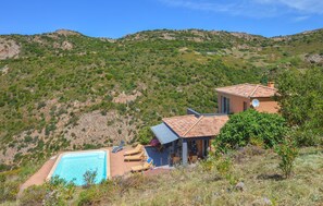 A hillside villa with a swimming pool, outdoor seating, and a view of the surrounding hills. - Lovely home in Appietto (Appietto)