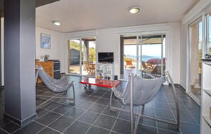 A modern interior with a dining area, a TV, and a view of the outdoors. - Lovely home in Appietto (Appietto)