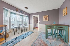 Ein Zimmer mit Essbereich, einer Küche und einem Flur.