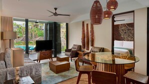A modern living room with a TV, seating, a glass table, and a ceiling fan. - Marriott Bali Nusa Dua Gardens 1 Bedroom Kitchenette 3 weeks (Badung Regency)