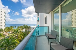 A balcony with a view of the ocean and palm trees. - Family & Friends Beach GetawayHollywood Beach- 2BR/2BA (Hollywood)