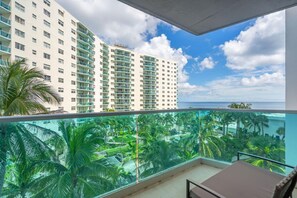 A balcony with a view of a resort area, including a pool and palm trees. - Family & Friends Beach GetawayHollywood Beach- 2BR/2BA (Hollywood)