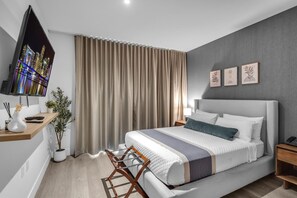 A modern bedroom with a bed, bedside tables, a TV, curtains, and wall art. - Bright & Modern Brickell Retreat-Prime Location- 7th Floor (Miami)