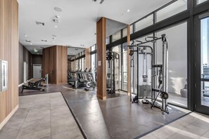 A modern gym with exercise equipment, large windows, and a clean, spacious layout. - Bright & Modern Brickell Retreat-Prime Location- 7th Floor (Miami)