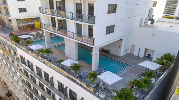 Et hotel med flere etager, et tagpoolområde, altaner og udsigt over de omkringliggende bygninger.