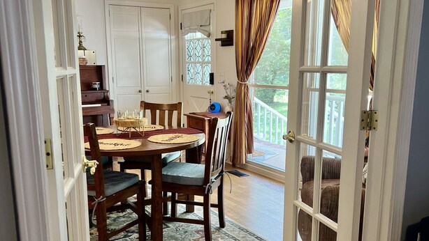 Un comedor con una mesa de madera, sillas y una lámpara colgante.