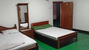 Een slaapkamer met een bed, een dressoir, een spiegel en een deur.