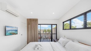 A hotel room with a bed, a painting, an air conditioning unit, a window, and a view of the outdoors. - MetaWiseBnB Bondi Junction Penthouse Style (Bondi Junction)