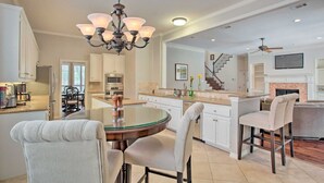 A spacious kitchen with a central island, white cabinetry, and a chandelier. - Private Pool & Hot Tub Suburban Retreat (Plano)